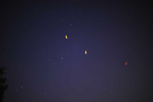 Blurry long exposure image showing streaks of orange light from Chinese Lanterns